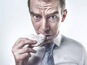 Dietary Supplements - man eating a sugary doughnut